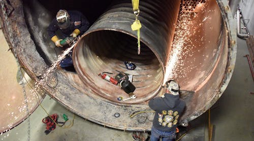 Boiler makers replacing the tubes and tube sheet in an industrial boiler.