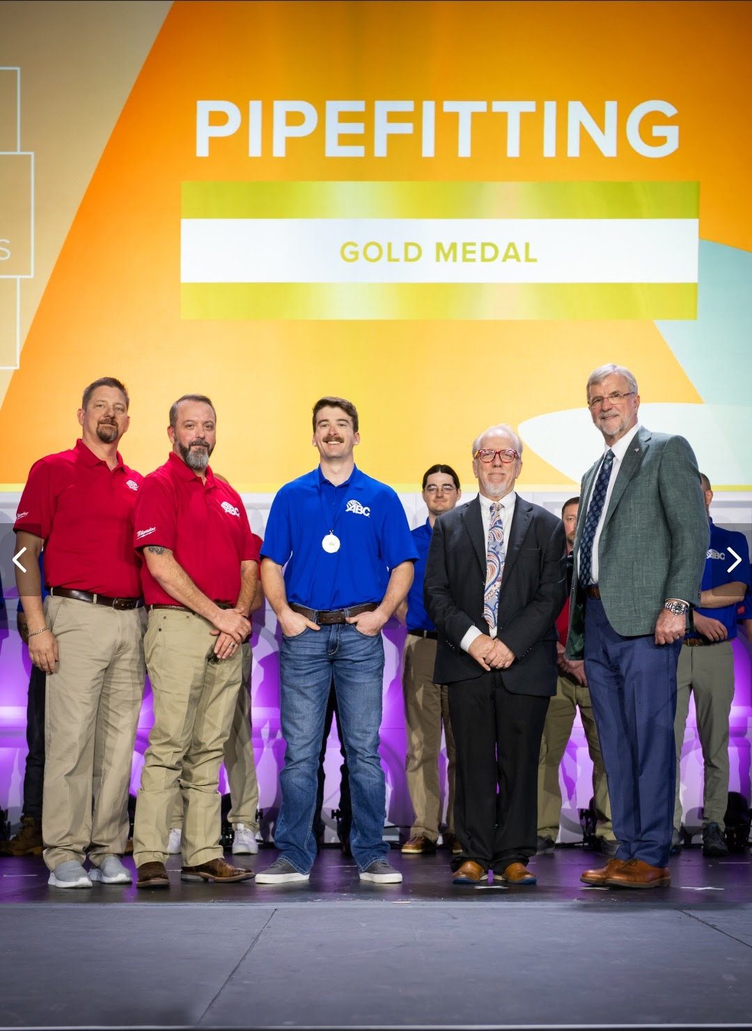 Tristian Wright (center) proudly wearing his gold medal in pipefitting from the 2023 National Craft Championships.