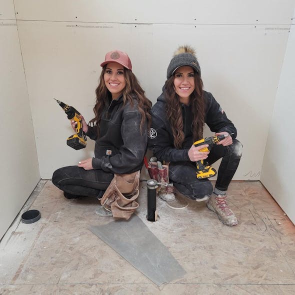 Two women drywallers who helped in the construction of the original House That She Built.