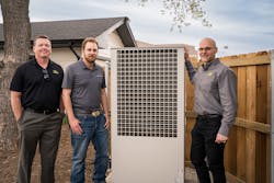 Group photo next to the heat pump's outdoor unit. Left to right are Jeremy Hobbs, J.M. O'Connor; Brice Walsten, J.M. O'Connor; Dave Trotter, Taco Comfort Solutions Group photo next to the heat pump's outdoor unit. Left to right are Jeremy Hobbs, J.M. O'Connor; Brice Walsten, J.M. O'Connor; Dave Trotter, Taco Comfort Solutions