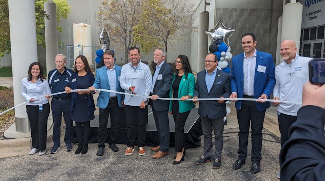 Uponor North America President Andres Caballero cuts the plastic pipe &apos;ribbon&apos; to open the company&apos;s new Experience Center.