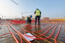 Technicians installing REHAU O2 Barrier pipe. Technicians installing REHAU O2 Barrier pipe.