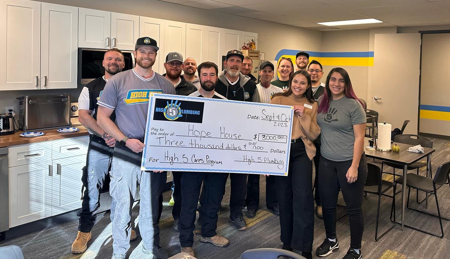 The High 5 Plumbing team donates a check for $3,000 to Hope House of Colorado.