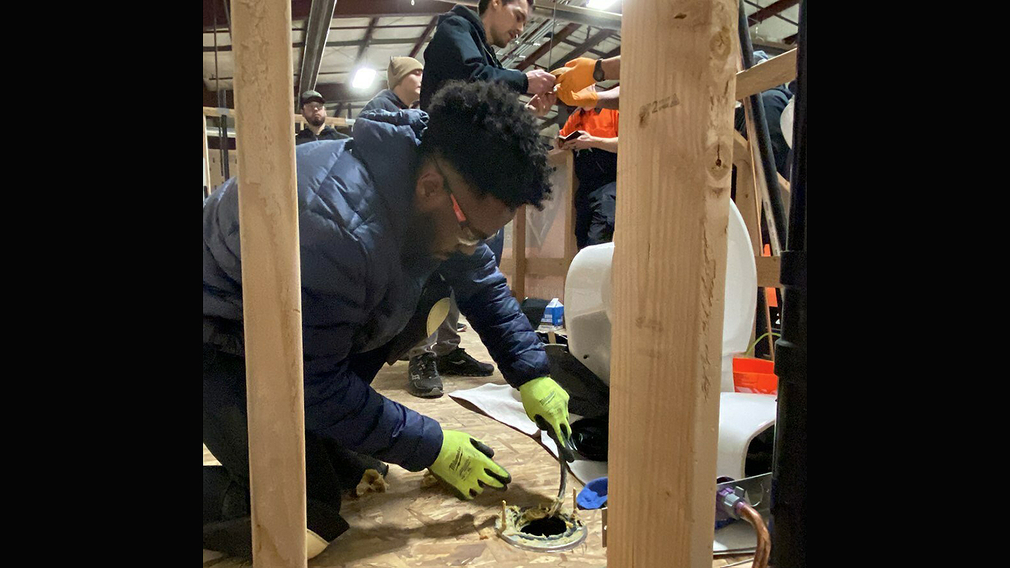 A plumbing trainee learning the trade.