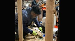 A plumbing trainee learning the trade. A plumbing trainee learning the trade.