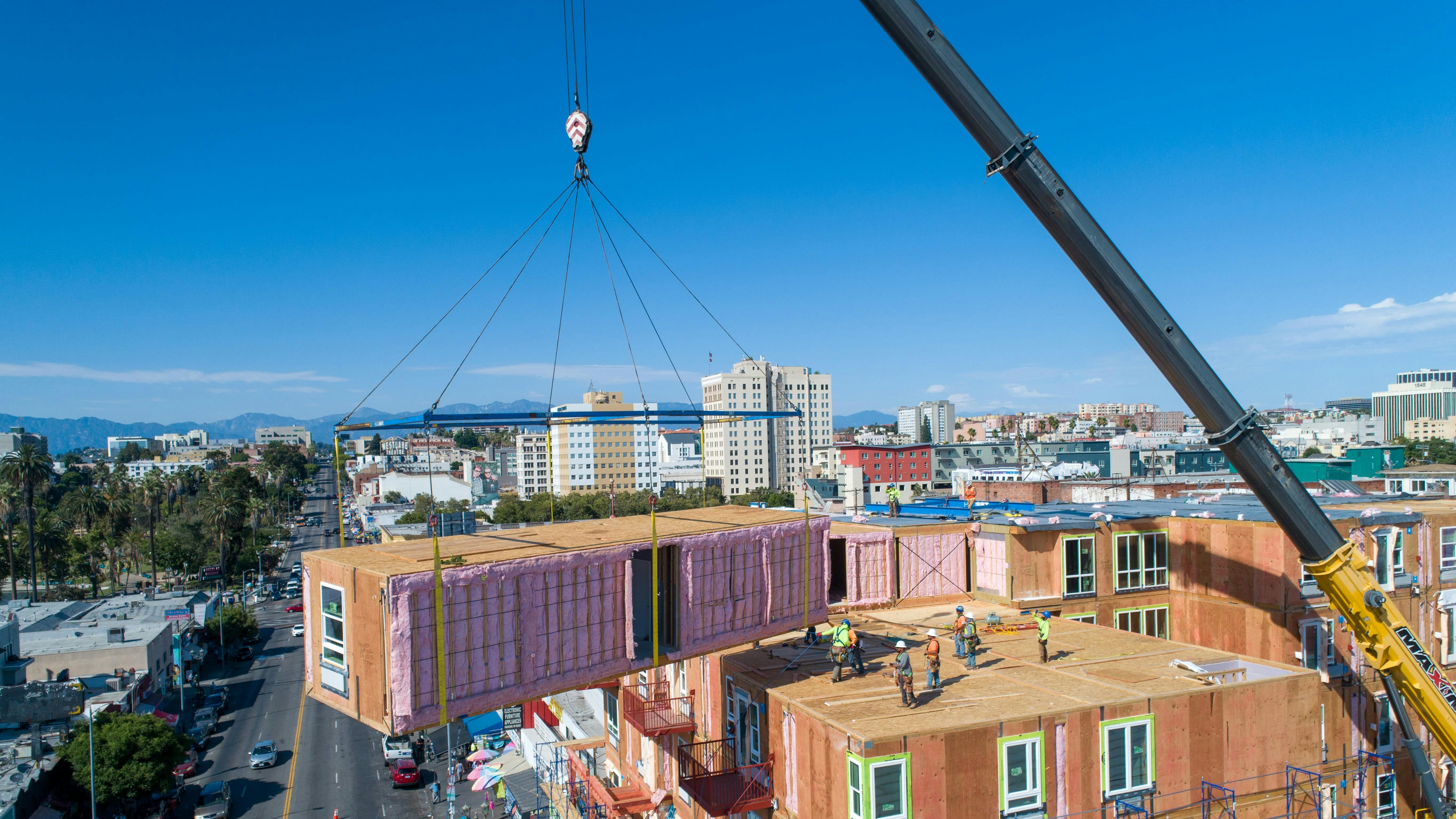 An Impact Housing module being placed on top of a building.