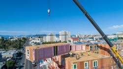 An Impact Housing module being placed on top of a building. An Impact Housing module being placed on top of a building.