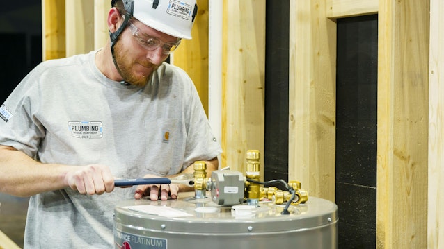 A 2023 contestant at work installing a water heater.
