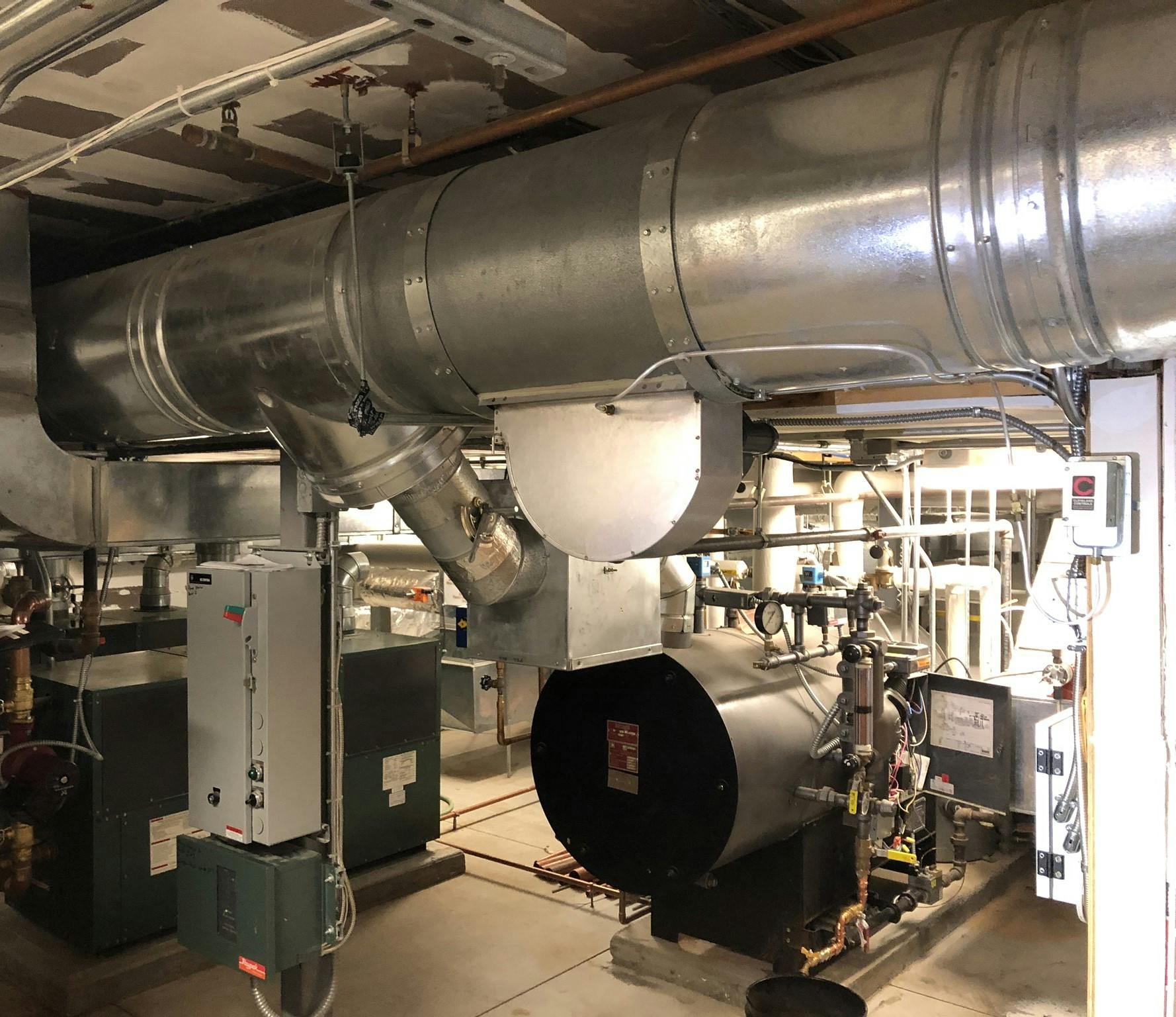 Old boilers and breeching in the mechanical room.