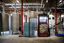 Moving canned beer into storage. Moving canned beer into storage.