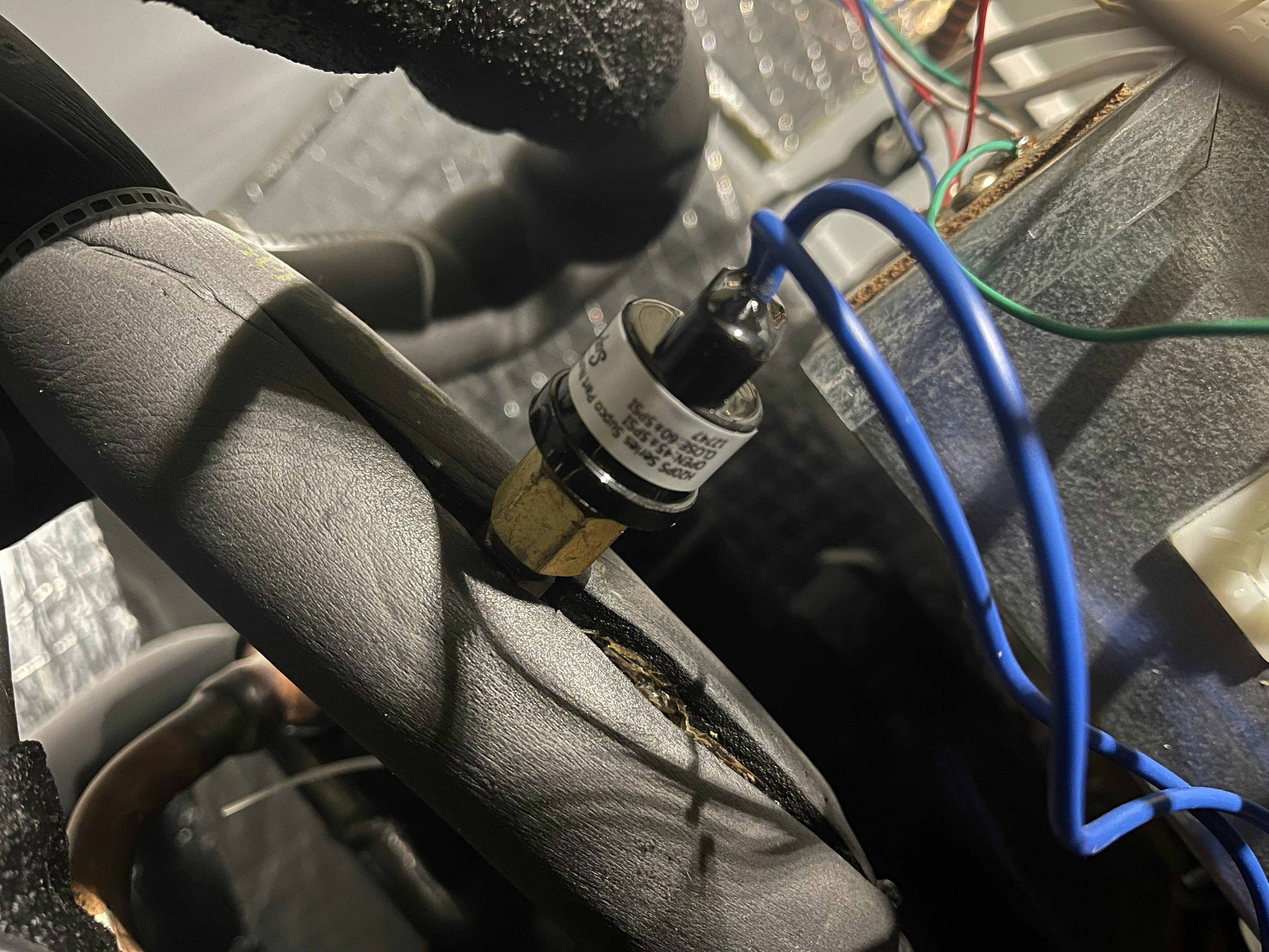 A defective refrigerant pressure switch leading to false low pressure faults.