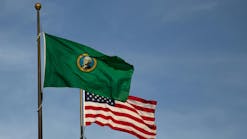 The state flag of Washington flies over the capitol in Olympia. The state flag of Washington flies over the capitol in Olympia.