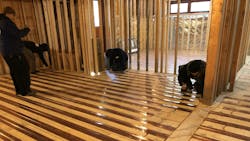 Nailing down copper radiant panels. Nailing down copper radiant panels.