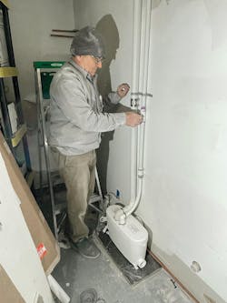 An extension pipe, roughed in through the wall, connects the macerator box to the toilet on the other side. The sink and shower discharge wastewater into the Saniaccess 3 via two-inch inlets on either side of the unit. An extension pipe, roughed in through the wall, connects the macerator box to the toilet on the other side. The sink and shower discharge wastewater into the Saniaccess 3 via two-inch inlets on either side of the unit.