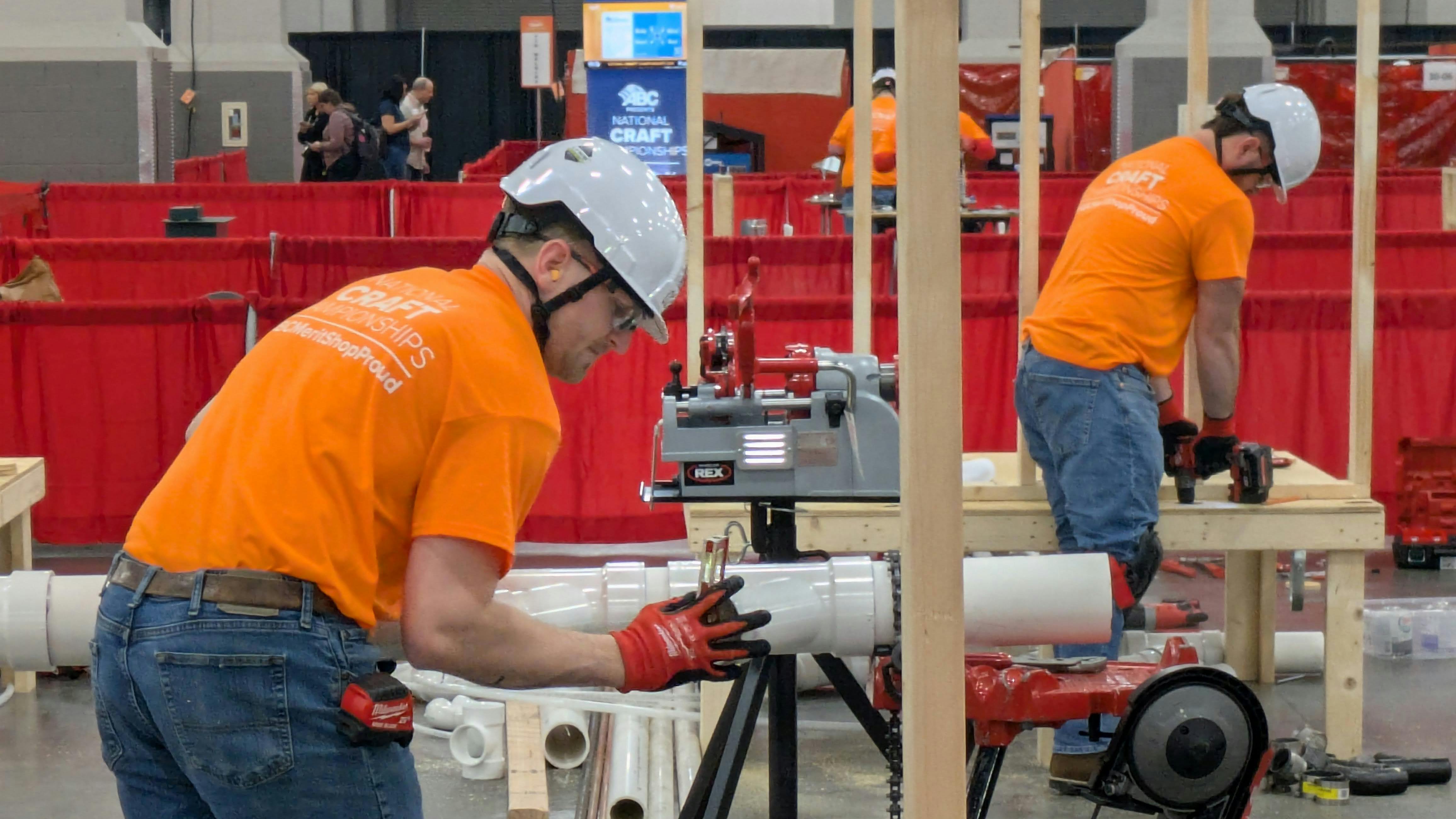 Competitors in the plumbing competition fit sections of PVC pipe during the 36th National Craft Competition.