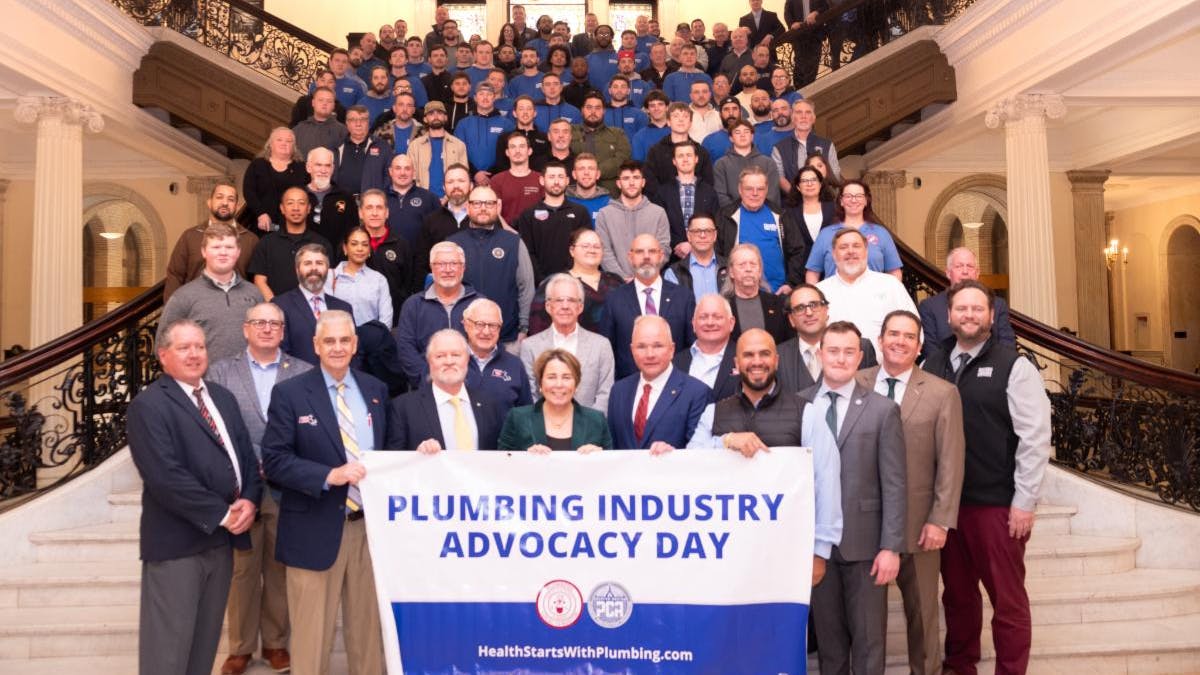 Massachusetts Gov. Maura Healey with the assembled plumbing industry representatives on the Grand Staircase of the Massachusetts State House.