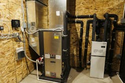 A ClimateMaster TES five-ton split with a matching variable speed air handler is used to help with backup heat as the overhead doors open and close throughout the day, A ClimateMaster TES five-ton split with a matching variable speed air handler is used to help with backup heat as the overhead doors open and close throughout the day,