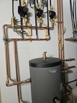 A section of the mechanical room with circulators and buffer tank. A section of the mechanical room with circulators and buffer tank.