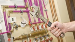 Servicing heating and water systems. Hand with adjustable wrench. Servicing heating and water systems. Hand with adjustable wrench.