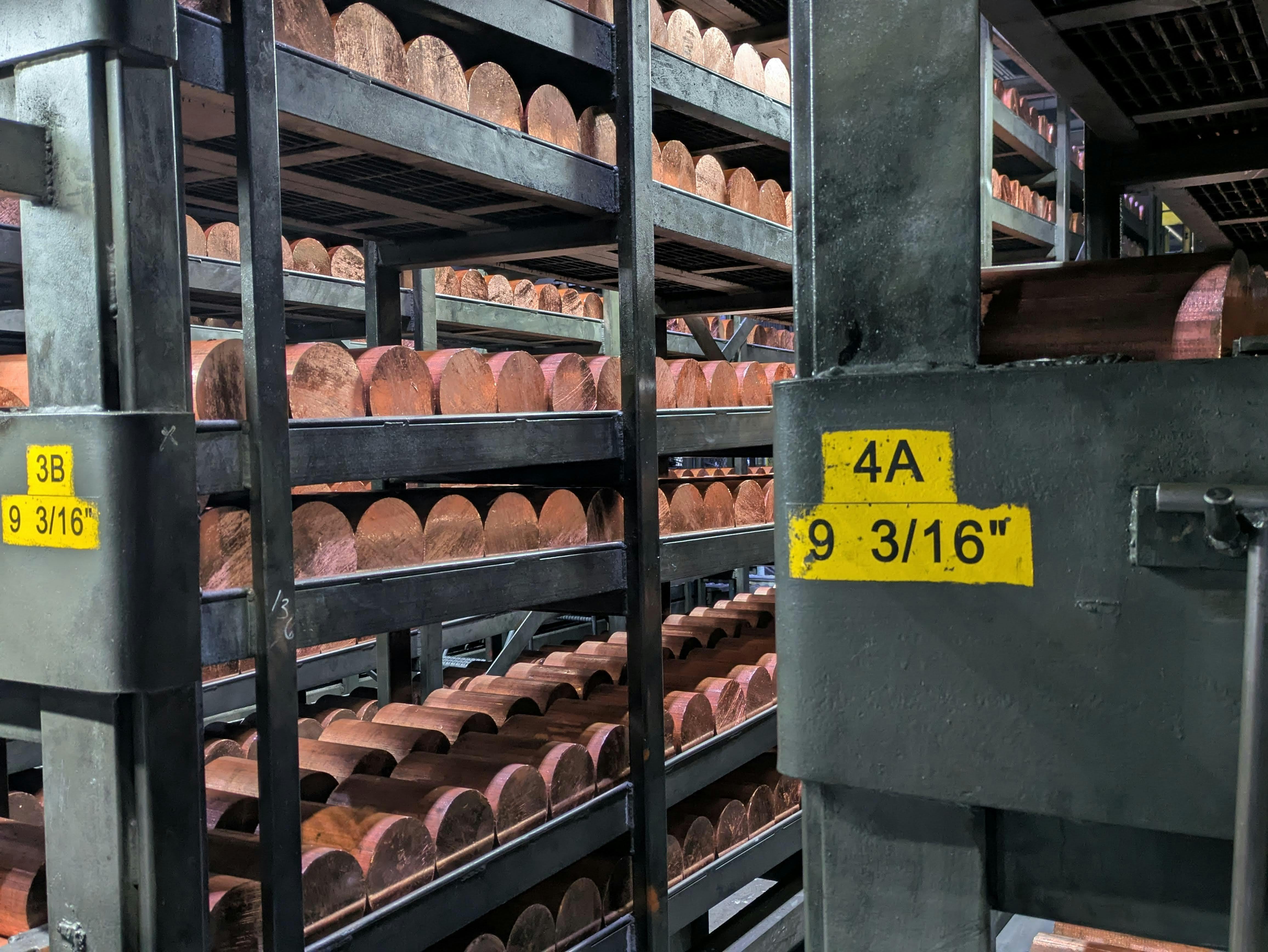 Copper billets sitting in racks.