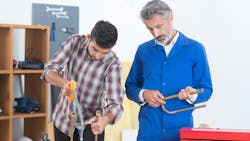Trainee plumber working on central heating boiler Trainee plumber working on central heating boiler