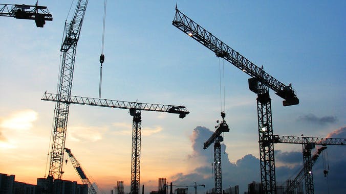 construction cranes at sunset