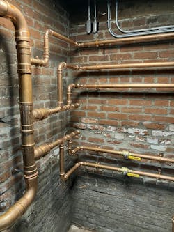 Flow from the system is coming from right and left to combine into the vertical 3” pipe, flowing down, or from the ceiling to the floor. The next two full size tees are part of the primary/secondary connection. Flow from the system is coming from right and left to combine into the vertical 3” pipe, flowing down, or from the ceiling to the floor. The next two full size tees are part of the primary/secondary connection.