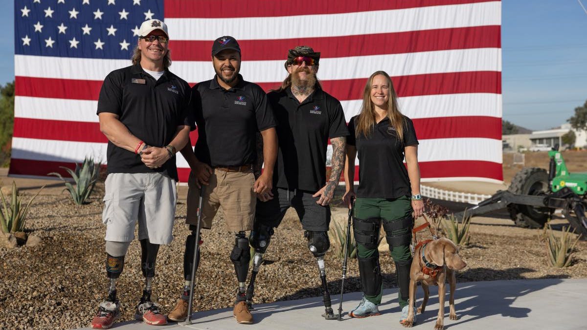 Veterans in front of a flag.