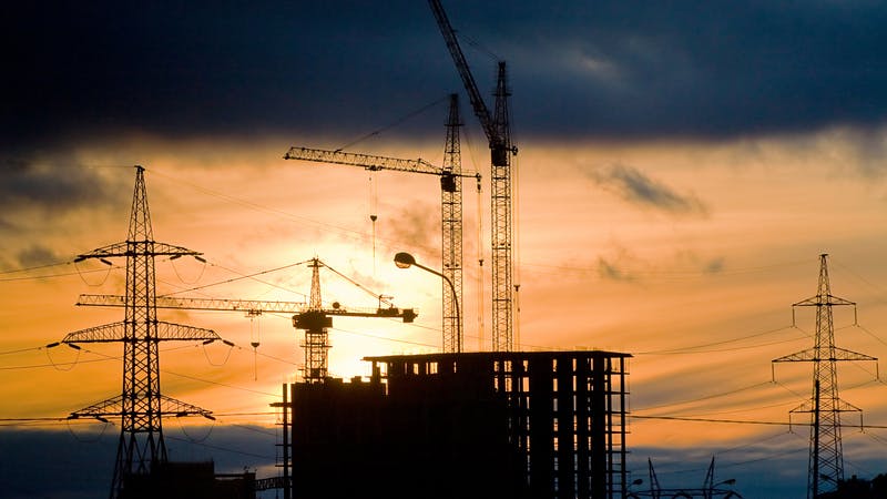 construction cranes at sunset.
