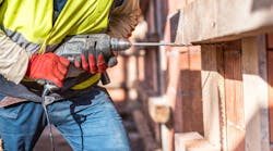 Worker using a drilling power tool Worker using a drilling power tool