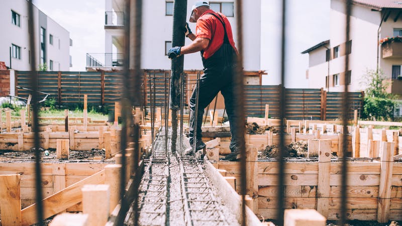Building construction worker pouring cement