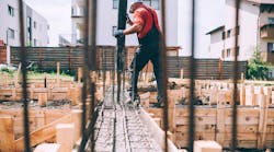 Building construction worker pouring cement Building construction worker pouring cement