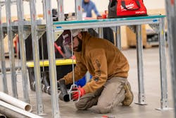 A competitor in the apprentice competition lines up a pipe hanger. A competitor in the apprentice competition lines up a pipe hanger.