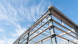 Steel frame workshop is under construction against a blue sky Steel frame workshop is under construction against a blue sky