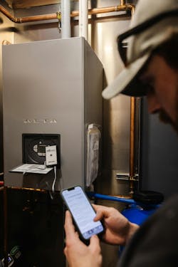 A technician troubleshoots an Alta boiler using the USB Connect App. A technician troubleshoots an Alta boiler using the USB Connect App.