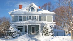 The front of a large older home covered in deep snow. The front of a large older home covered in deep snow.