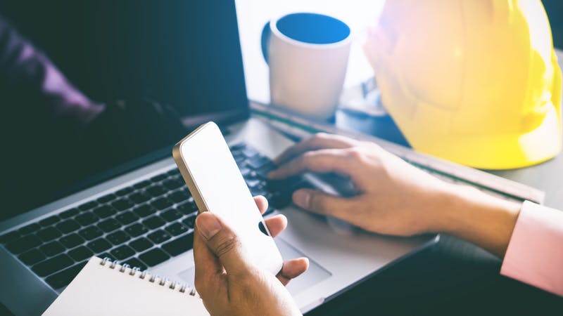 Construction Engineer using phone to contact customer