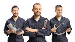 Team of plumbers holding plumbing equipment Team of plumbers holding plumbing equipment