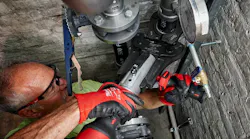 Plumber using a press tool. Plumber using a press tool.