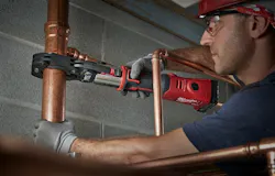 Plumber using a press tool.