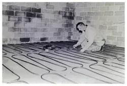 Company Founder Paul Schlosser Sr. performing an early radiant installation. Company Founder Paul Schlosser Sr. performing an early radiant installation.