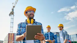 Builder in hardhat with tablet pc at construction site. Builder in hardhat with tablet pc at construction site.