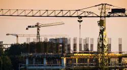 Cranes and construction site at dusk Cranes and construction site at dusk