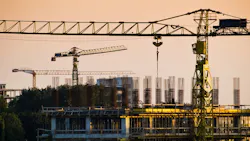 Cranes and construction site at dusk Cranes and construction site at dusk
