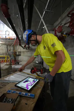 An E. M. Duggan tech working from a piping diagram. An E. M. Duggan tech working from a piping diagram.