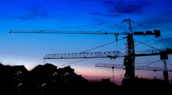 construction cranes at sunset construction cranes at sunset