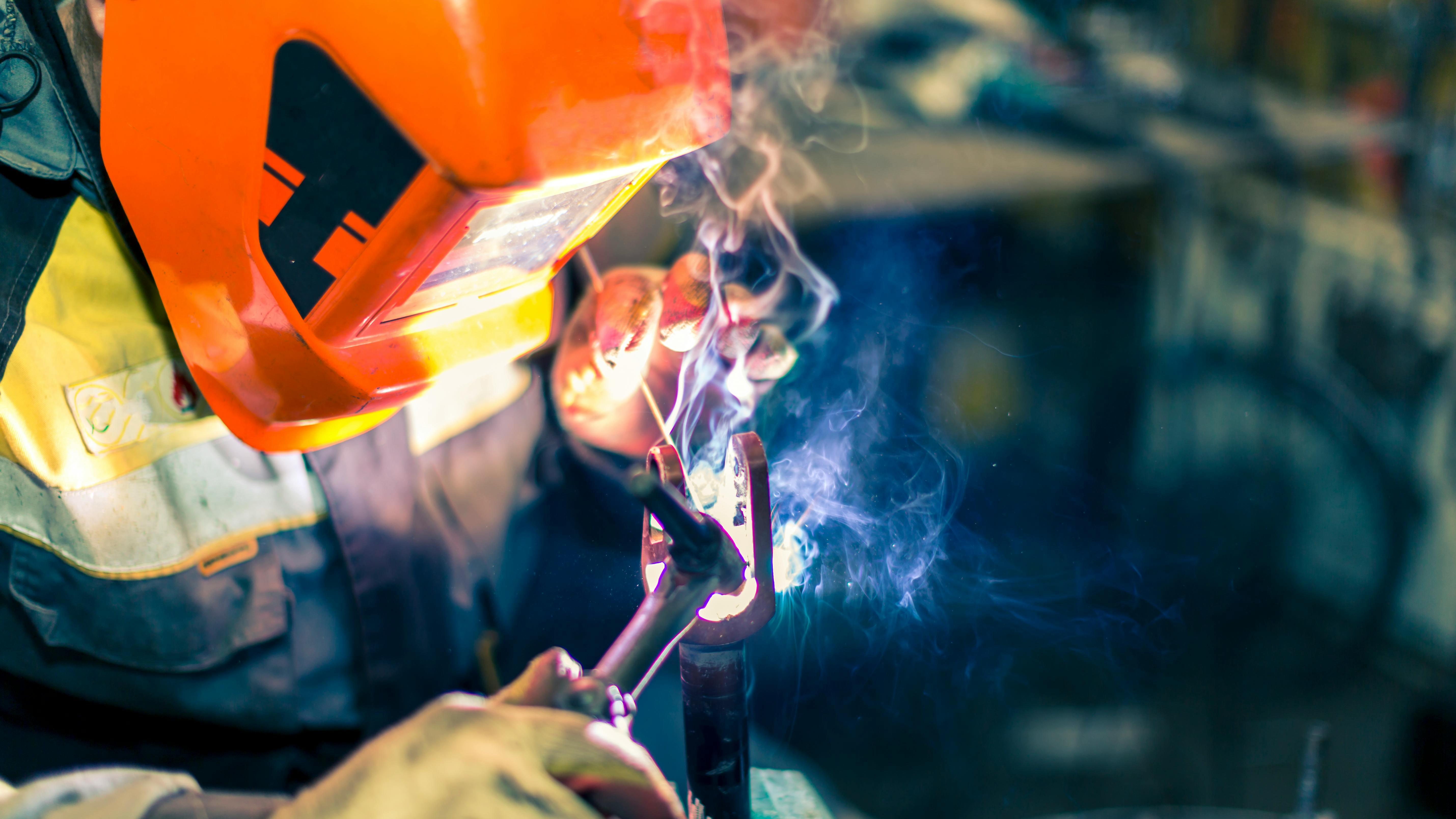 Welder at work in protective gear.