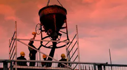 Silhouettes of construction workers pouring concrete mix at the building site Silhouettes of construction workers pouring concrete mix at the building site