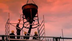 Silhouettes of construction workers pouring concrete mix at the building site Silhouettes of construction workers pouring concrete mix at the building site