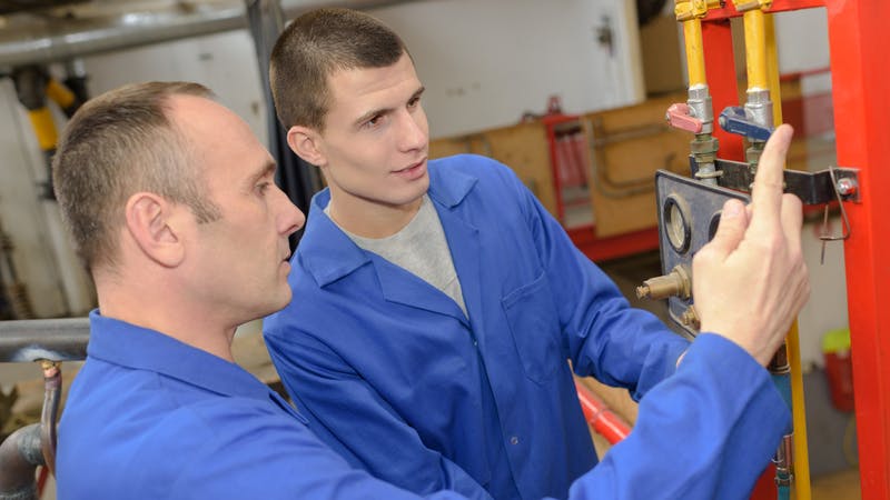 Plumbing teacher encouraging apprentice